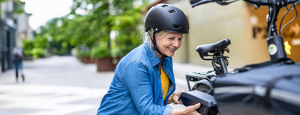 Image of senior woman working with the storage compartment on her bike